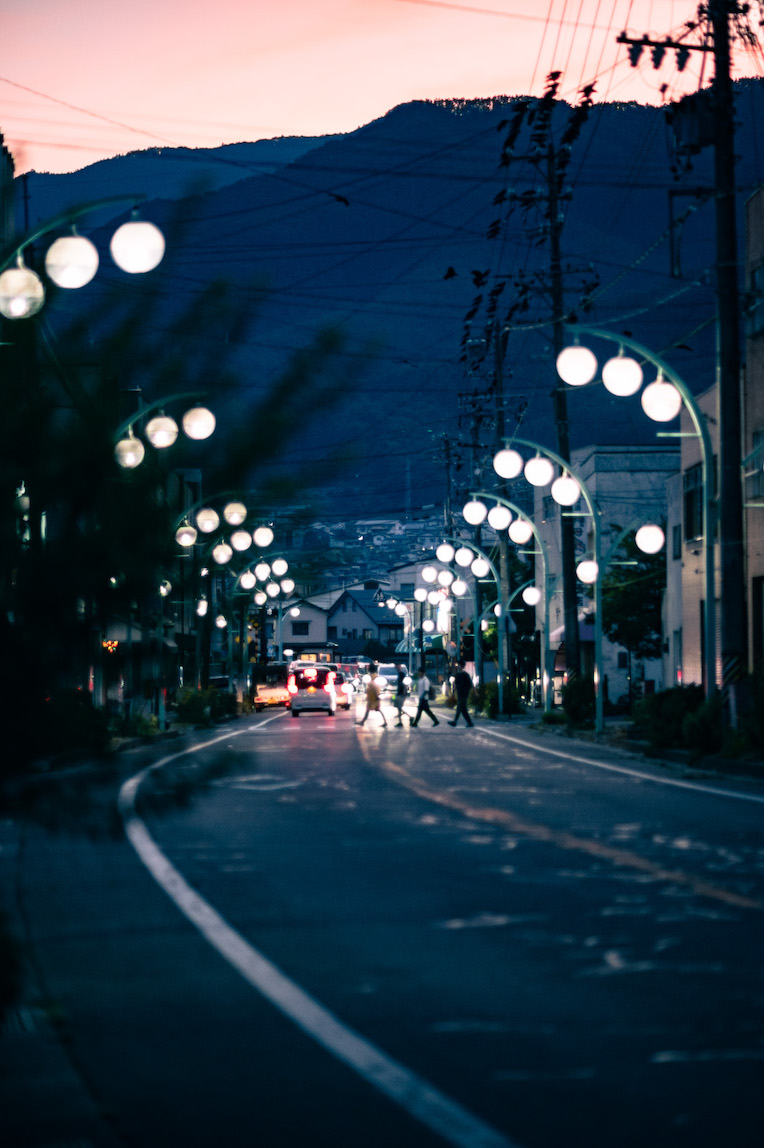 夕暮れの辰野町商店街。街灯がともる道路